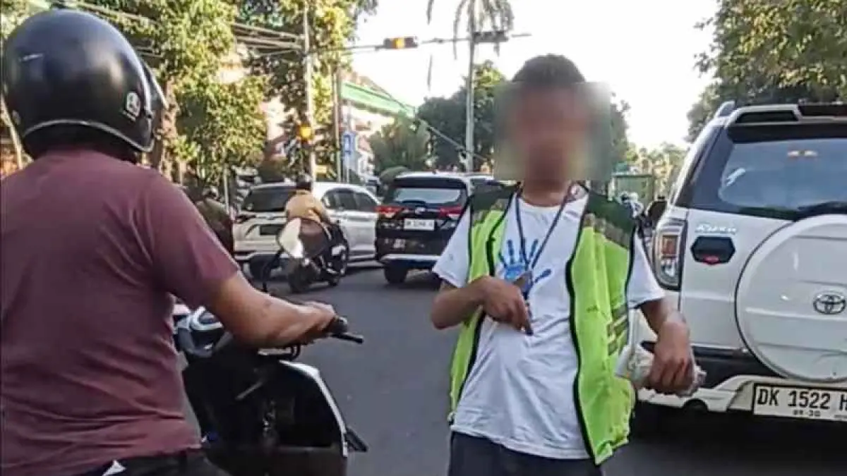 HARUSNYA BUKAN DI KAWASAN BERISIKO KECELAKAAN:Penyandang disabilitas ini dipekerjakan sebagai juru parkir di kawasan badan Jalan Lapangan Puputan Badung . (Adrian Suwanto/Radar Bali)