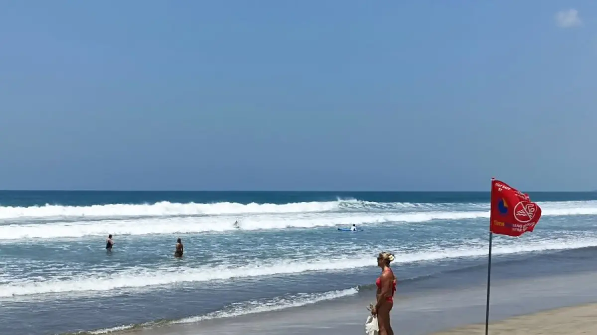 LANGIT TANPA AWAN: Pengunjung pantai dan wisatawan menikmati serunya bermain selancar disaat cuaca sedang cerah di musim kemarau. (MIFTAHUDDIN HALIM/radarbali.id)