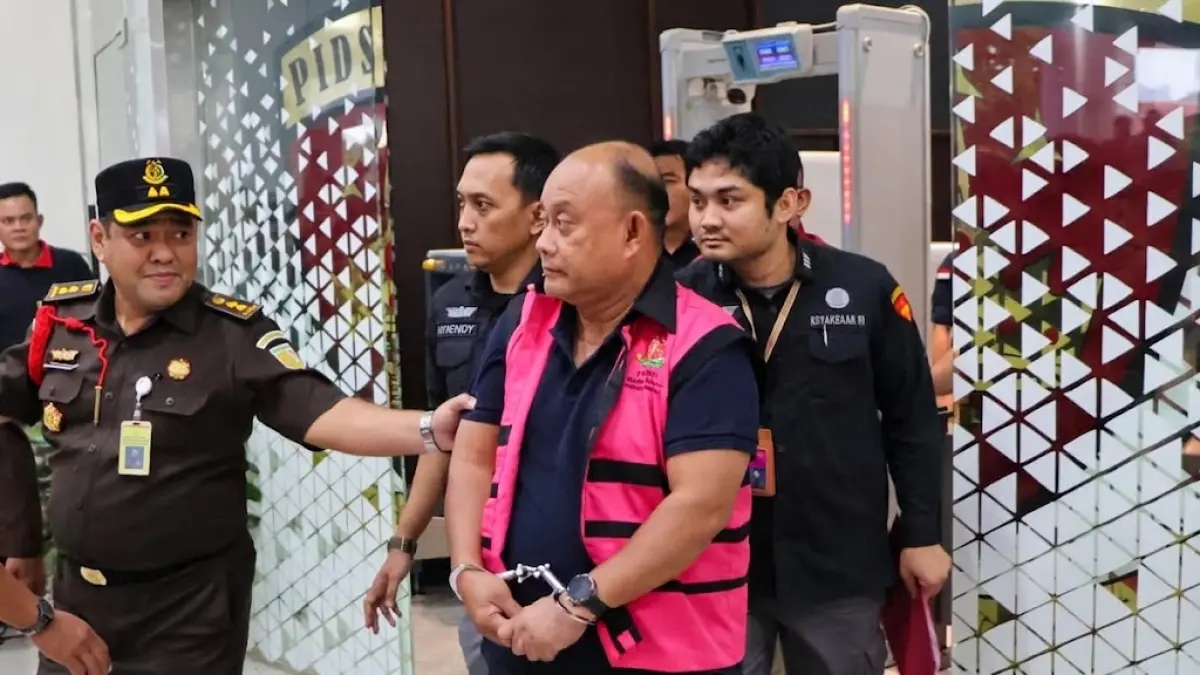 Penyidik Kejaksaan Agung memborgol eks Kepala BGN Dadan HIndayana seusai ditetapkan sebagai tersangka korupsi program Makanan Bergizi Gratis.