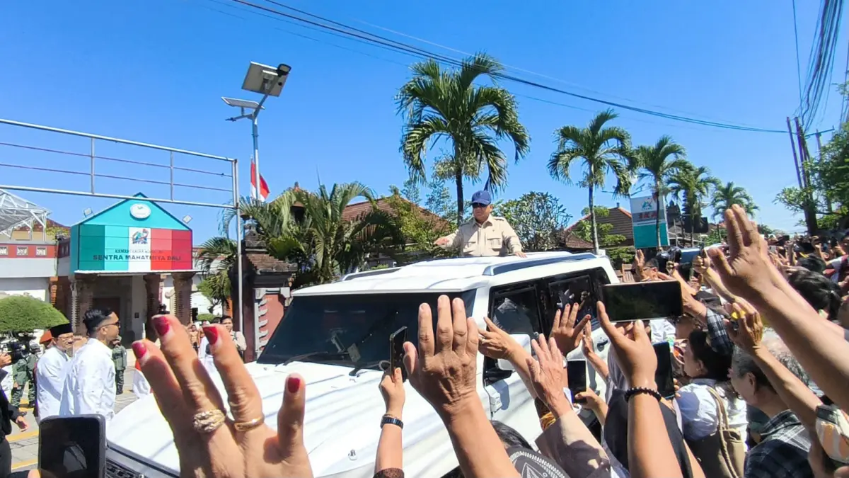 DARI SEKOLAH RAKYAT: Ratusan warga dan siswa menyambut kedatangan Presiden RI Prabowo Subianto di area lapangan Renon Denpasar dari atas kendaraan dan menyapa warga. (ADRIAN SUWANTO/radarbali.id)