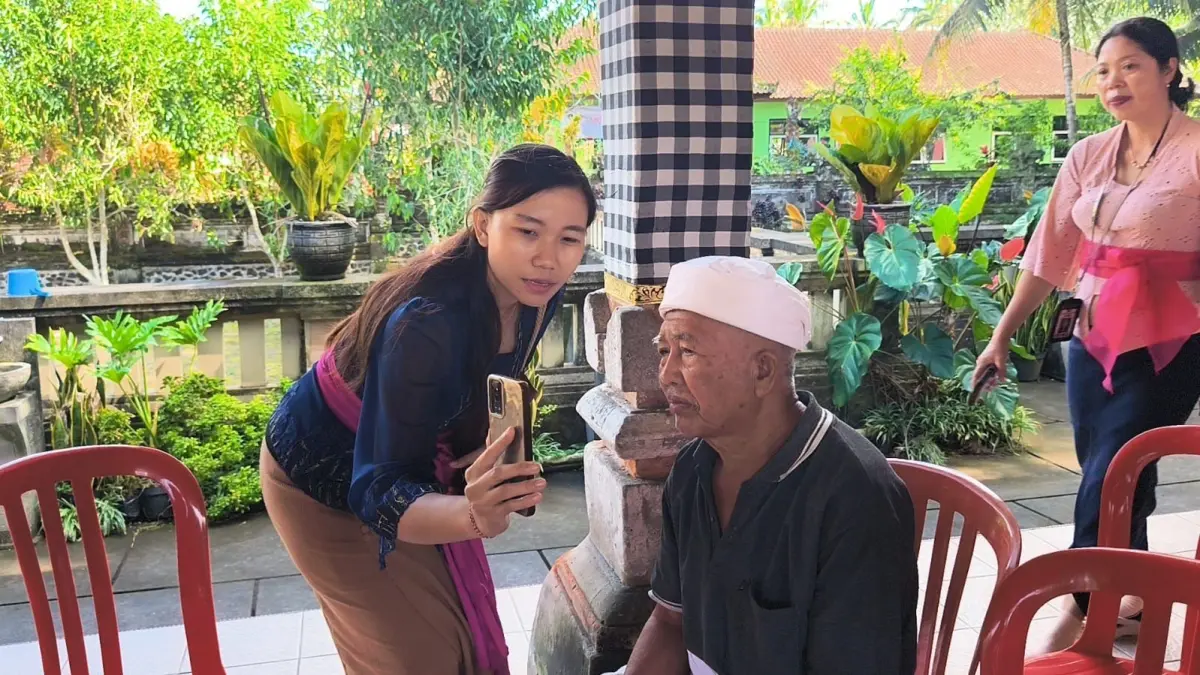 Pendamping melakukan aktivasi aplikasi Perlinsos bagi keluarga penerima manfaat bantuan sosial di Bali. (Foto: Kemenpan RB)