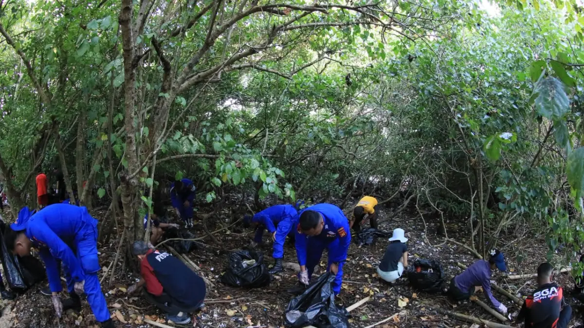 AKSI KONGKRIT: Relawan dan aparat berbaur memberisihkan sampah di area Mangrove dalam kegiatan Clean Up di Mangrove Benoa. (ISTIMEWA/radarbali.id)