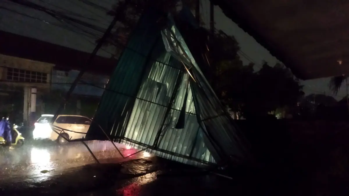 BENCANA: Petugas Polsek Denpasar Barat melakukan pengecekan pohon tumbang dan bangunan rusak di kawasan Jalan Imam Bonjol, Denpasar, Jumat (12/6/2026).