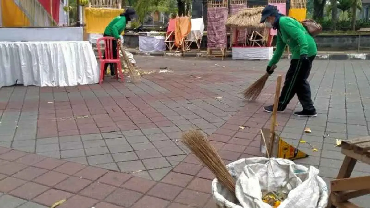 KERJA KERAS DI HARI RAYA: Petugas kebersihan Tabanan Tengah melakukan pembersihan sampah sisa upacara. (juliadi/radar bali).&nbsp;