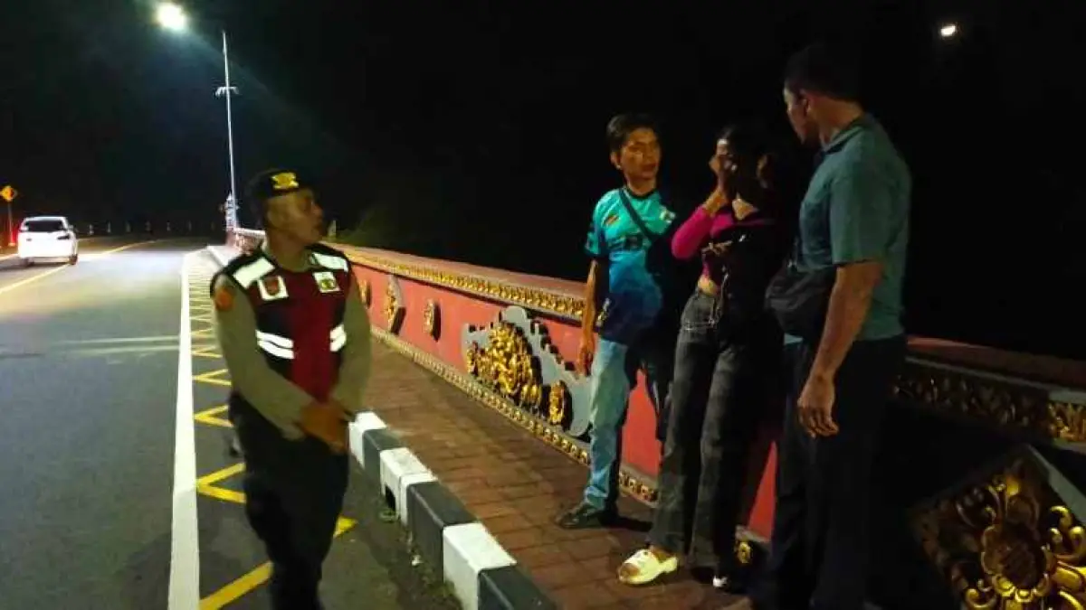TERSELAMATKAN : Polisi mencegah NMS dari percobaan bunuh diri &nbsp;di jembatan &nbsp;shortcut Singaraja-Mengwitani Titik 8. (foto: Polres Buleleng)