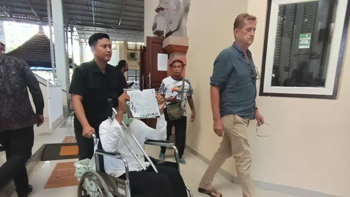 DISKON BESAR: Nirul Rashim Abdoelrazak menutupi wajahnya usai menjalani sidang di PN Denpasar, Selasa (23/6).
