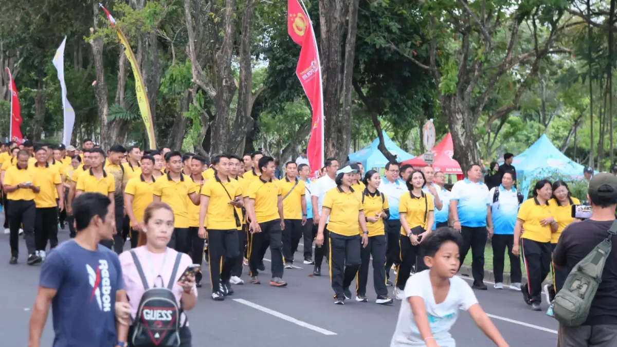 LAUTAN KUNING: Lintasan lapangan Renon Denpasar penuh sesak dengan peserta jalan masal HUT Bhayangkara 2026. (ist/radarbali.id)
