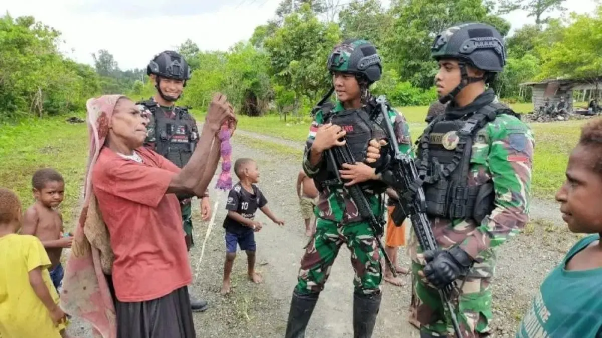 MENYATU: Warga  dan anak-anak Wamena Papua sudah menyatu dan bercanda dengan tentara penjaga keamanan setempat tanpa rasa waswas. (ist/radarbali.id) 