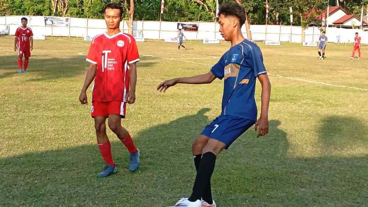 DEMAM SEPAK BOLA DUNIA: Pemain PLTU (kiri, seragam merah) dan Persica (kanan, seragam biru) berebut bola dalam ITT Cup I. Kejuaraan ini menjadi salah satu bukti iklim sepak bola yang rutin terlaksana di wilayah Kecamatan Gerokgak.(Francelono Junior)
