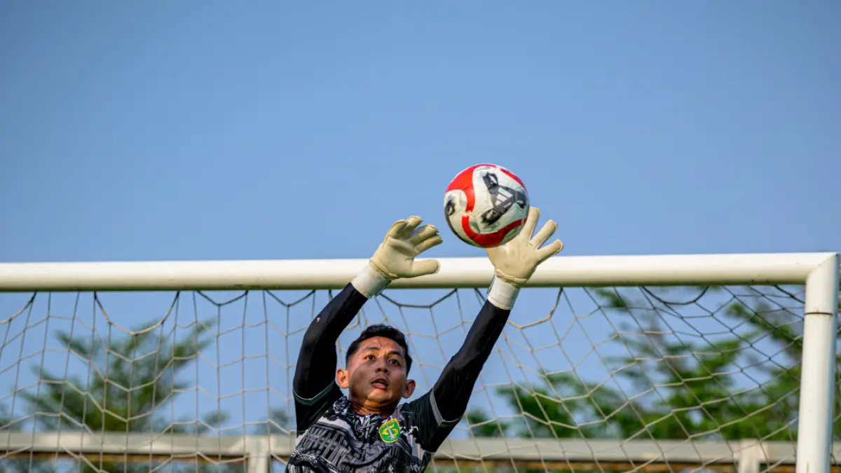 Kiper Persebaya Reza Arya Pratama berlatih menjelang bertemu Persija di Piala Presiden 2026. Eks kiper utama PSM Makassar ini berebut tepat di skuad Persebaya dengan kiper senior Ernando Ari Sutaryadi, Kenzo Albar, dan Ilham Al-Arif. (Foto: Persebaya)