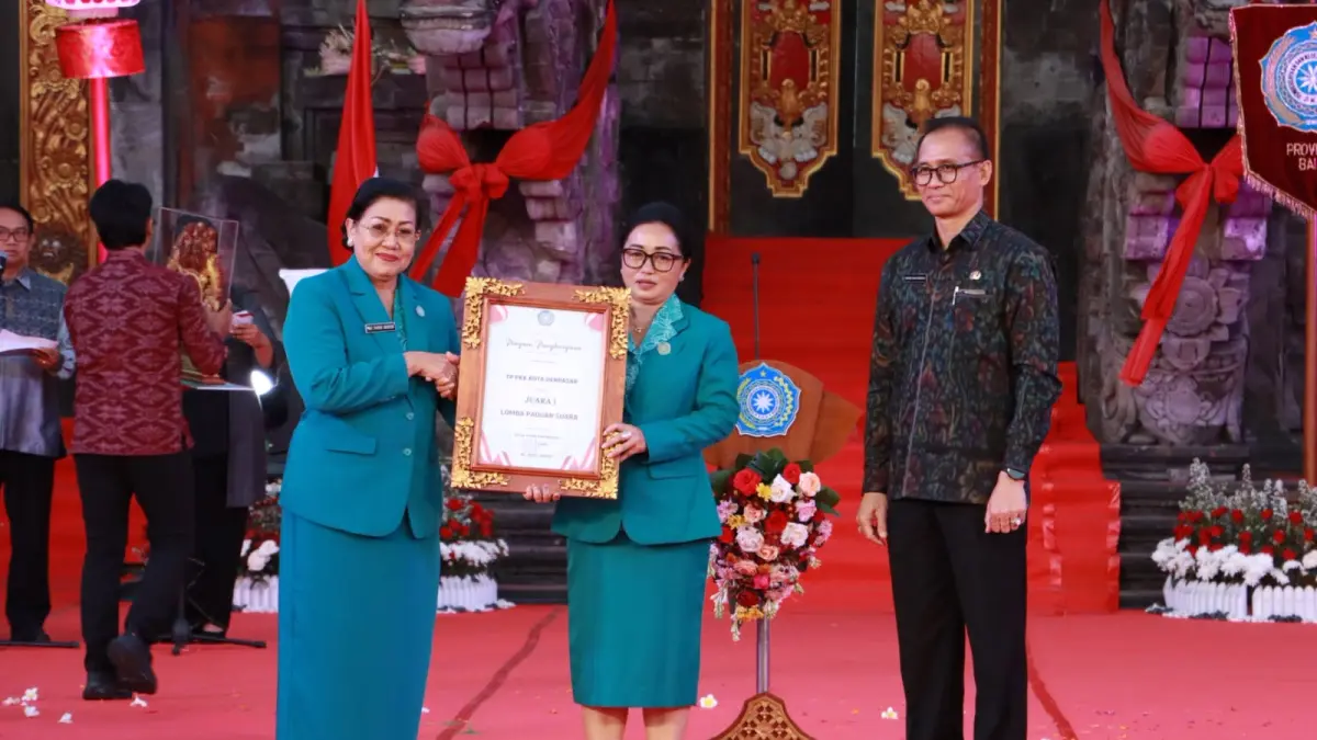 

Ketua TP PKK Kota Denpasar, Ny. Sagung Antari Jaya Negara saat menerima Piagam penghargaan lomba Juara I dalam Lomba Paduan Suara pada perayaan puncak Peringatan Hari Kesatuan Gerak (HKG) PKK Ke-54 Tingkat Provinsi Bali Tahun 2026 di Panggung Terbuka Ardha Candra Art Center, Denpasar pada Jumat malam (24/7).