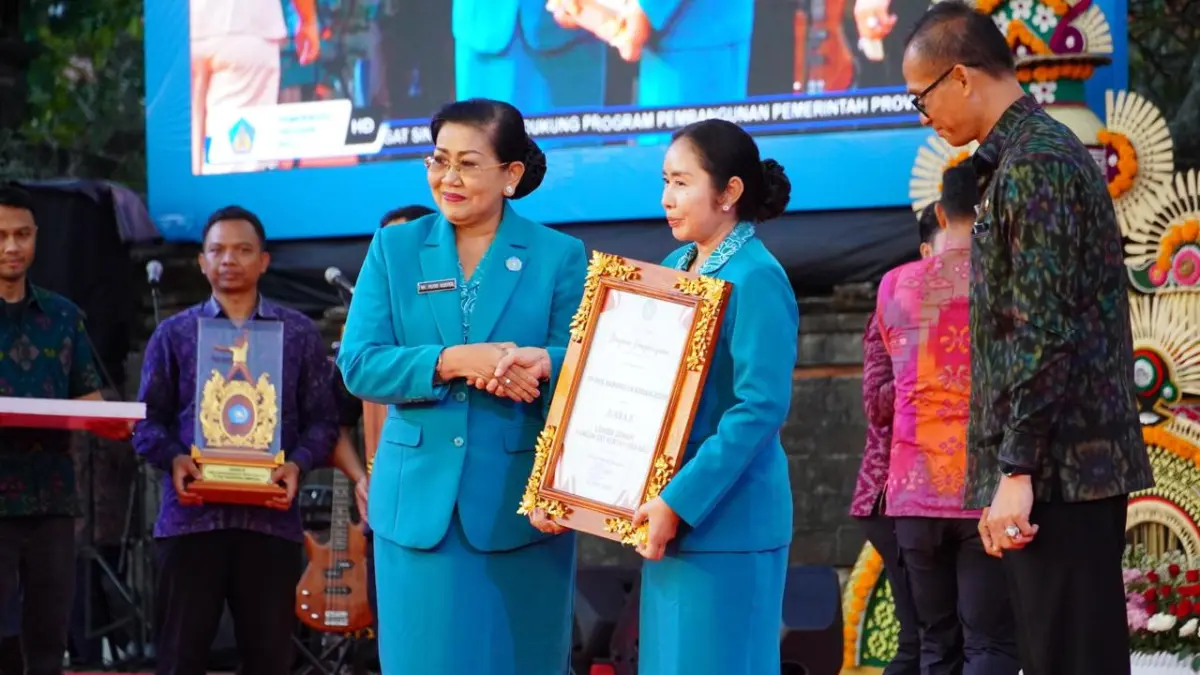 Ketua TP PKK Kabupaten Karangasem, Ny. Mas Parwata saat menerima penghargaan usai kontingen TP PKK Kabupaten Karangasem meraih juara II lomba senam pada Puncak Peringatan Hari Kesatuan Gerak (HKG) PKK ke-54 Tingkat Provinsi Bali di Denpasar.