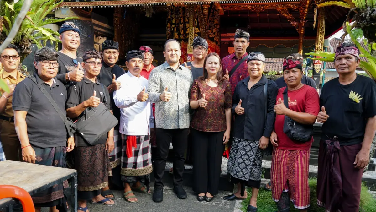 Wabup Bagus Alit Sucipta didampingi Ketua GOW Badung Nyonya Yunita Alit Sucipta menyerahkan Piagam Penghargaan Tertib Administrasi Pengurusan Akta Kematian dan Kartu Keluarga (KK) kepada ahli waris I Made Subagia di Banjar Belawan, Desa Dauh Yeh Cani, Abiansemal, Senin (27/7).