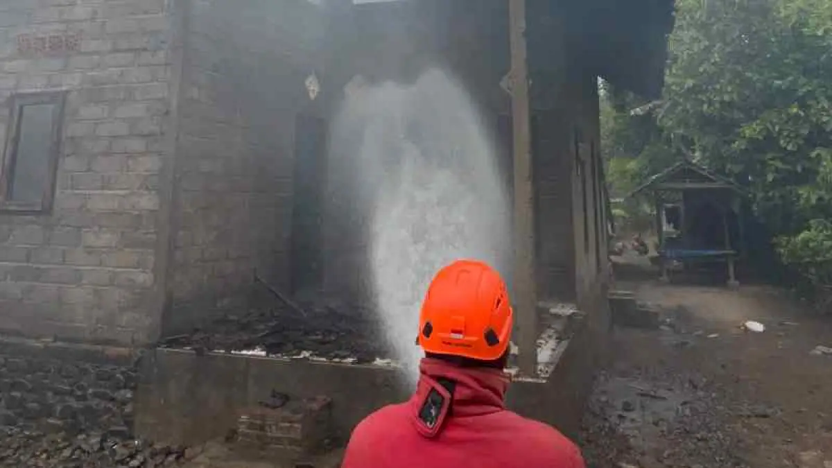 TERBAKAR SAAT DITINGGAL : Petugas Damkar memadamkan kobaran api di rumah milik I Ketut Sumerta, di Banjar Ketiman, Desa Manistutu, Kecamatan Melaya, Jembrana. (Damkar Jembrana