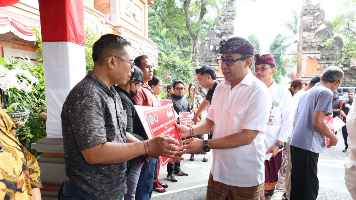 Wali Kota Denpasar, I Gusti Ngurah Jaya Negara saat menyerahkan secara simbolis bantuan pasca bencana kepada 25 perwakilan penerima di lobi Kantor Wali Kota Denpasar, Jumat (14/8) pagi.