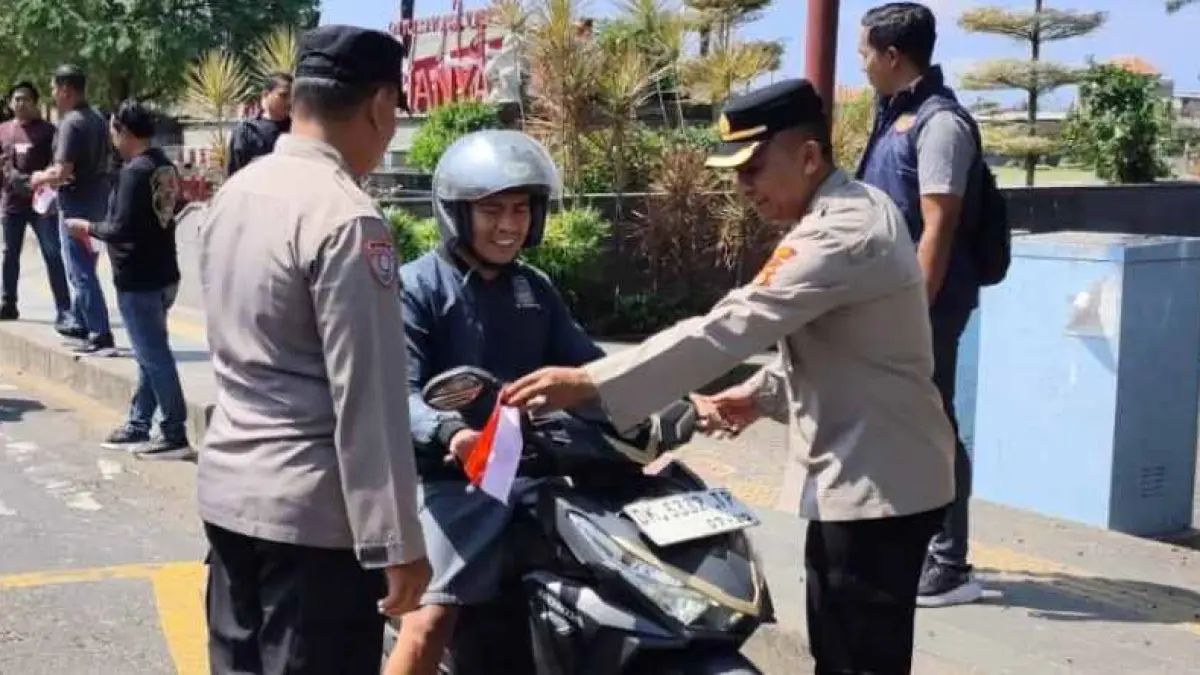PASANG BENDERA KECIL :&nbsp;Jajaran Polres Gianyar &nbsp;menyetop pengendara dan memasang bendera kecil di spion kendaraan.(foto:Polres Gianyar)