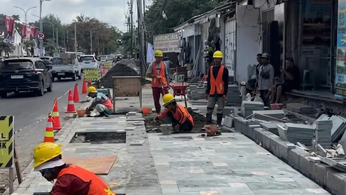 Pekerja sedang memasang pedestrian di Jalan Pantai Kuta, Kuta Selatan. Pemkab Badung sedang membangun pedestrian selebar 3,5 meter mulai Hotel Hard Rock hingga Pullman Legian. 
