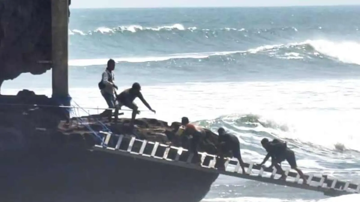 PERTARUHKAN NYAWA : Sejumlah buruh tampak menyeberang untuk menuntaskan proyek pembangunan pura Batu Bolong. (foto: IG Ketut Dewantara untuk Radar Bali)