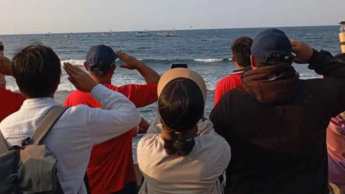 DISAMBUT ANTUSIAS: Masyarakat memberi hormat ke bendera merah putih yang berkibar dari bawah ke permukaan perairan Kerobokan.(francelino junior)