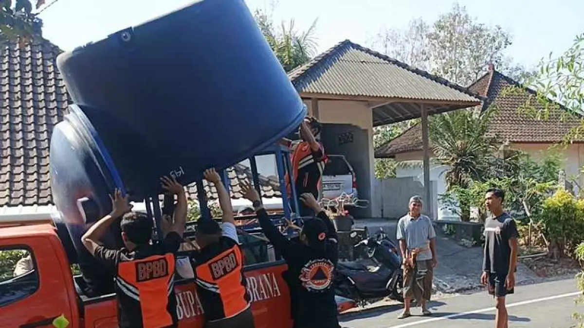 SEBARKAN GALON TANDON RAKSASA: Petugas BPBD Jembrana memasang tandon air di wilayah krisis air bersih di Desa Yehembang Kauh. (foto: BPBD Jembrana)