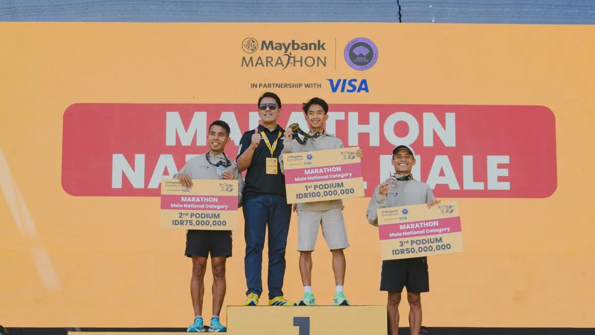 Juara 1, 2, dan 3 kategori Marathon National Male memegang cek hadiah di atas podium, saat acara penyerahan hadiah Maybank Marathon 2026 in Partnership with Visa di Bali United Training Center, Gianyar, Bali, pada 23 Agustus 2026