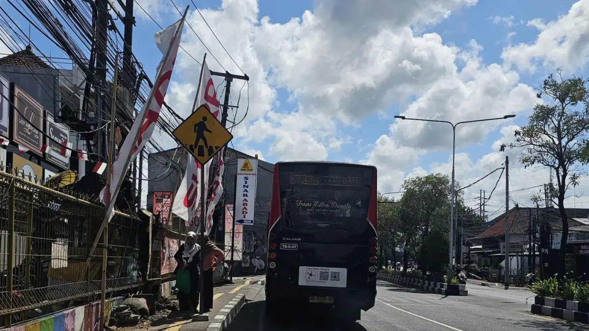 TANPA HALTE: Bus Trans Metro Dewata saat di pemberhentian di Jalan Imam Bonjol, penumpang naik di tepi jalan bukan dari halte. Bus TMD ini akan ditemani oleh Bus Listrik. (NI KADEK NOVI FEBRIANI/radarbali.id)
