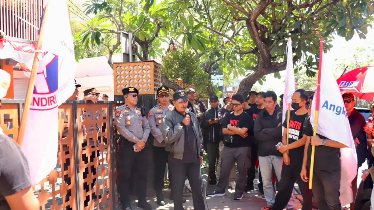 GERUDUK: Personel Polresta Denpasar mengawal aksi penyampaian aspirasi FSPM Regional Bali di depan Kantor PT Angkasa Pura Support (APS) Cabang Denpasar, Jalan Bypass Ngurah Rai, Tuban, Kuta, Badung, Kamis (27/8/2026). (ADRIAN SUWANTO/radarbali.id)