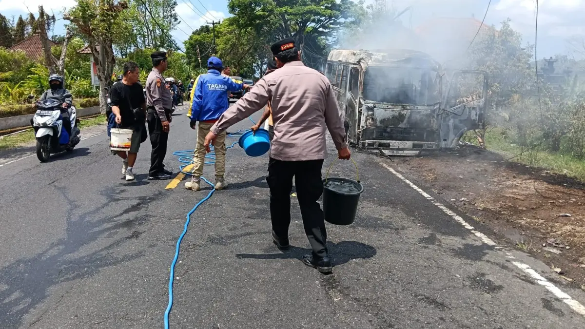 ASTAGA! TERBAKAR DI JALANAN : Isuzu Elf yang mengangkut belasan penumpang wisatawan lokal yang terbakar di Jalan Denpasar-Singaraja.&nbsp;(foto:Istimewa)
