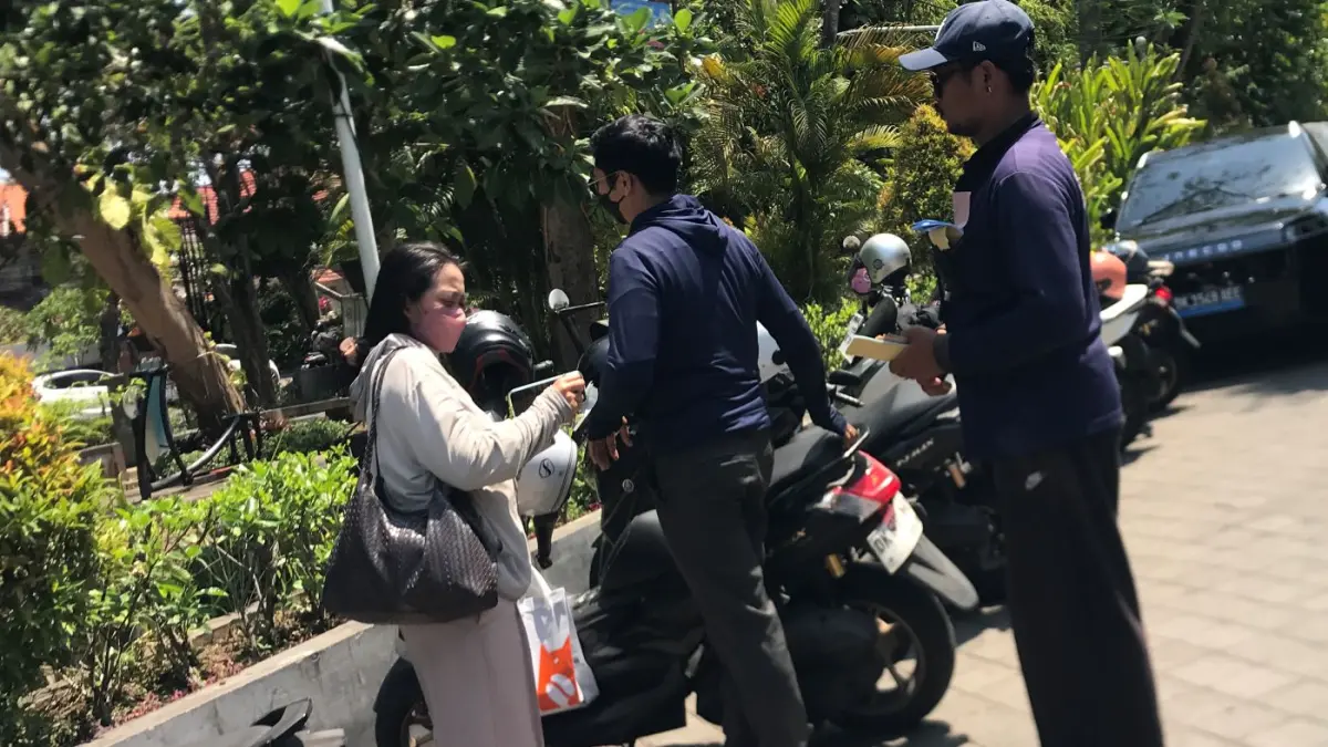 BELUM BEBAS PARKIR: Warga pengendara motor membayar parkir di Jalan ade Irma Suryani Nasution, Renon, Denpasar, Senin 21 September 2026. (MIFTAHUDDIN HALIM/radarbali.id)