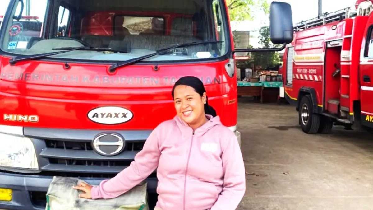 TUNTASKAN NGIDAM : Ni Putu Lilik Mas Juliantari naik mobil Damkar. (foto:Istimewa)