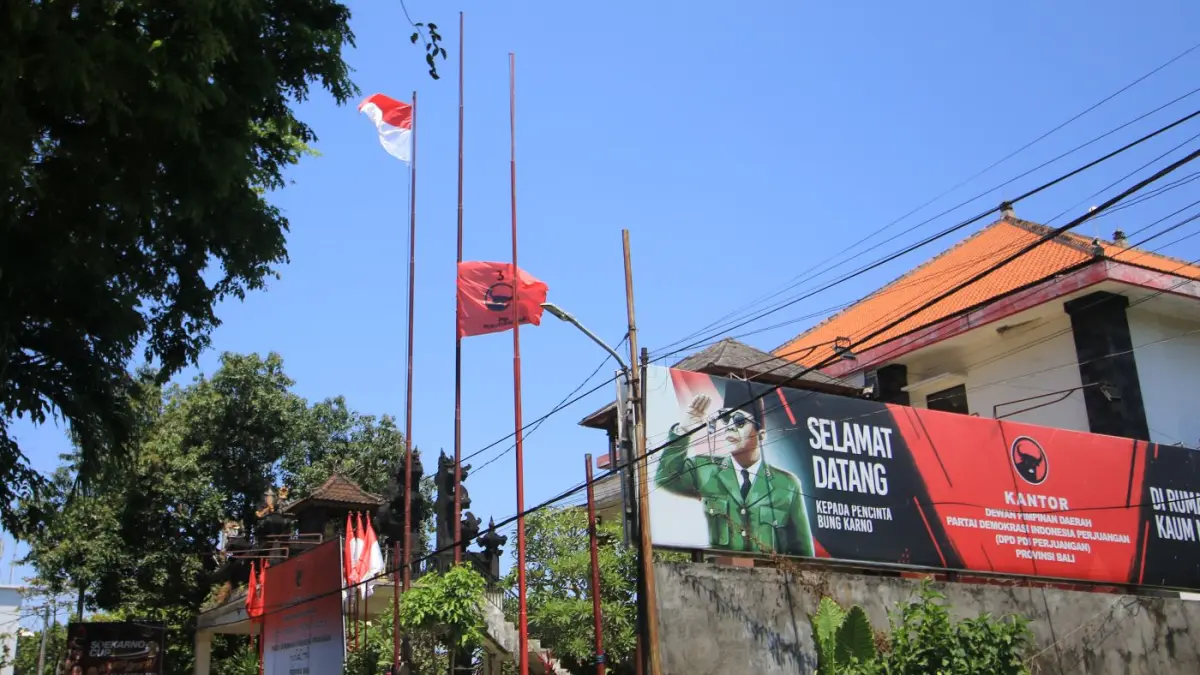 SETENGAH TIANG: Bendera PDI Perjuangan dikibarkan setengah tiang di Sekretariat Renon sebagai wujud berkabung wafatnya Guruh Sukarnoputra. (MIFTAHUDDIN HALIM/radarbali.id)