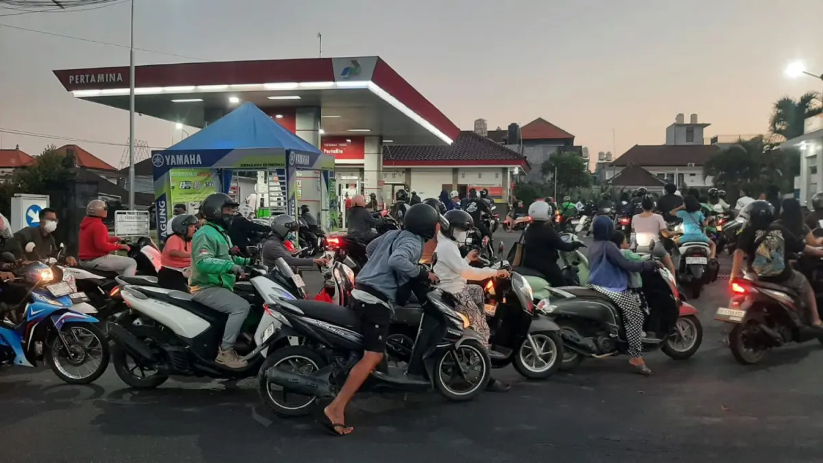 MELINGKAR DAN MENGULAR: Antrean BBM khususnya sepeda motor di SPBU Dalung Permai Kuta Utara Badung mengular hingga makan badan jalan. Pertamina mengakui pasokan belum stabil. (M. RIDWAN/radarbali.id)