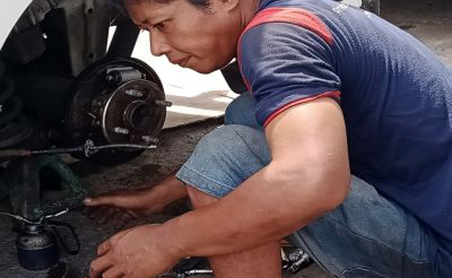 Handoko saat mengecek kondisi mobil Avansa di bengkelnya. (maulana sandijaya/radarbali)