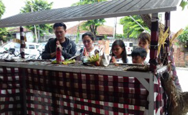 BERDOA: Tiari Bintang (kaos putih) bersama vokalis Band Lolot Made Bawa bersembahyang di area kamar jenazah RS Sanglah kemarin. (juliadi/radarbali)