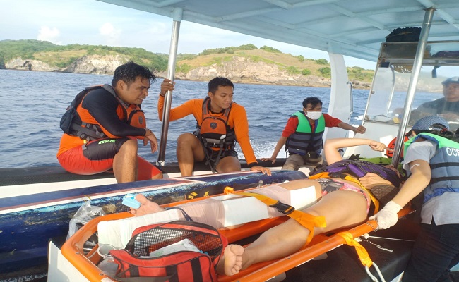 Petugas mengevakuasi wisatawan asal Italia, Alessandra setelah digulung ombak saat berenang di Pantai Klingking.  (ist)