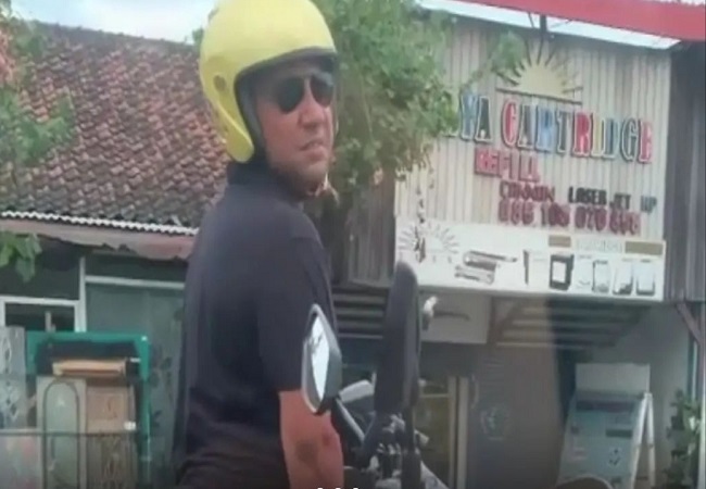 Bule tepergok kencing di lampu merah kawasan Densel. Videonya viral di medsos. (Screen capture media sosial)