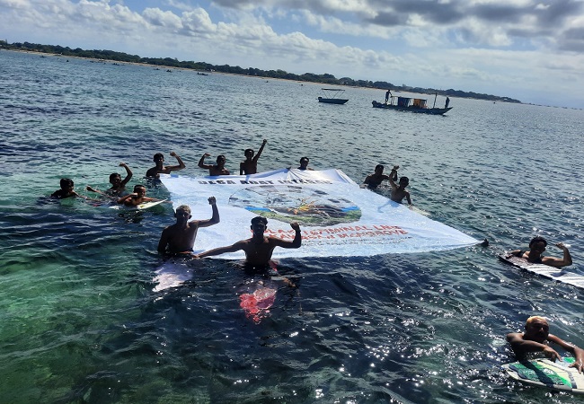 TOLAK LNG: Sejumlah komunitas peselancar menggelar aksi di laut dengan membentang spanduk penolakan proyek LNG beberapa waktu lalu.