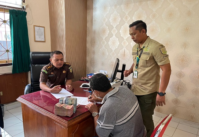 Salah seorang pengurus LPD anturan kembalikan uang reward. (Eka Prasetya)