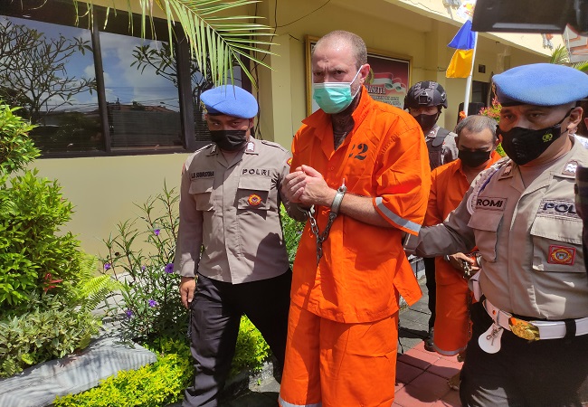 Tersangka Jason Peabodyfunkwyler Clark asal  Amerika Serikat saat dikawal polisi ke sel tahanan. Dia ditangkap polisi karena menyimpan ganja cair. (Marsellus Nabunome Pampur)
