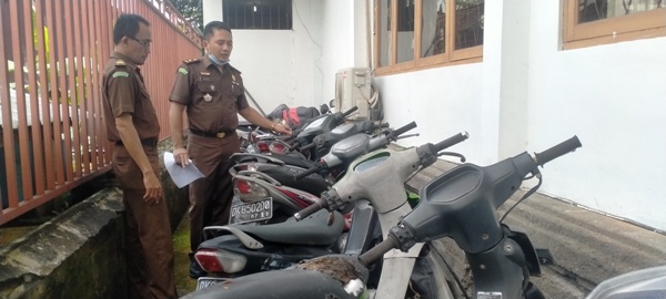 TAK KUNJUNG DIAMBIL : Kasi Pindum Kejari Tabanan IDGP Awatara (kanan) yang menunjukkan BB tilang perkara tahun 2018-2022 (foto : juliadi/radar bali).