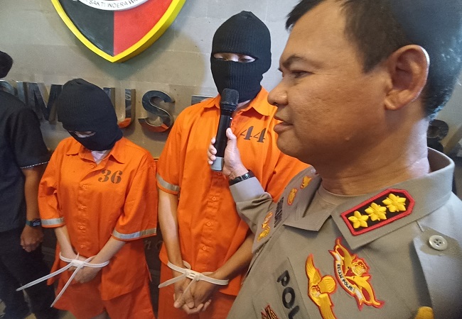 Dua tersangka pemeran video mesum di dalam mobil saat diperlihatkan ke media, kemarin. (Adrian Suwanto)