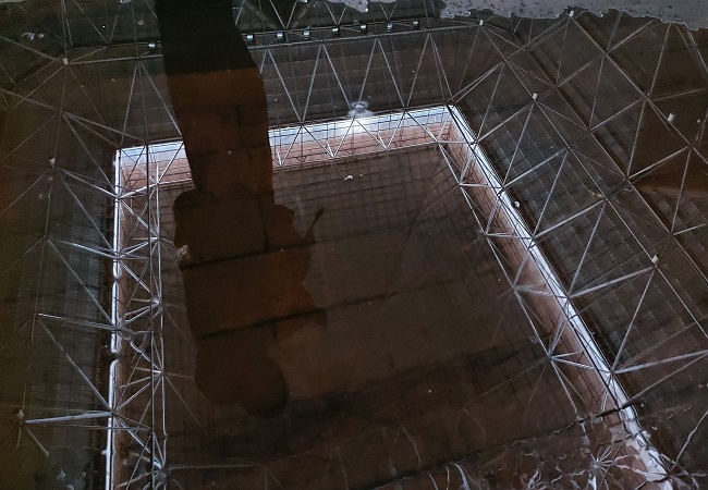 Refleksi struktur bagian dalam GOR Lila Bhuana terlihat di genangan air di bagian timur lantai kayu. Cabor futsal direncanakan akan memakai GOR ini untuk Porprov Bali XV/2022. (ALIT BINAWAN/RADAR BALI)