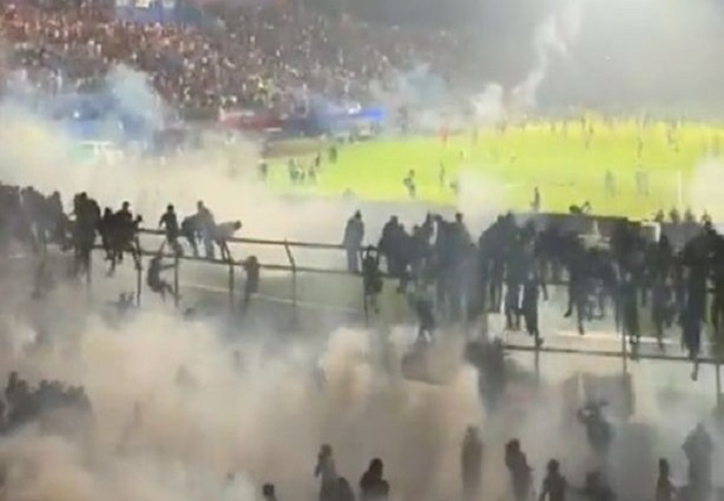 Penembakan gas air mata mengiringi kericuhan yang terjadi setelah laga antara Arema FC melawan Persebaya di Stadion Kanjuruhan, Kabupaten Malang (1/10). Dari kejadian itu ratusan suporter tewas. (Twitter)