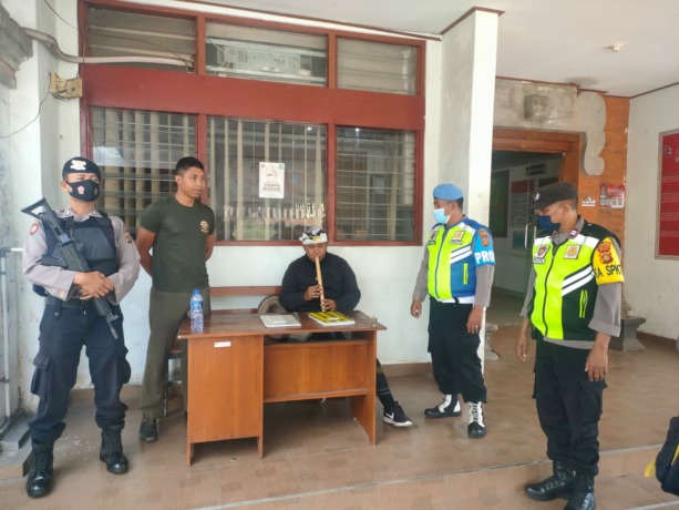 SEMBUNYI: Putu Tisna, tersangka pembacokan di Kerobokan Kuta Utara saat diserahkan Satpol PP Karangasem kepada polisi