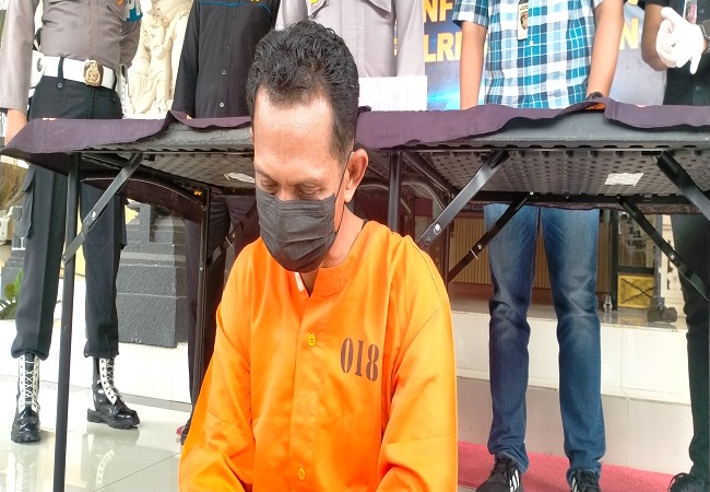 Tersangka I Kadek Eva Apridana diamankan polisi. Dia tega menyetubuhi anak kandung sendiri dan ponakannya. (Foto/Juliadi)