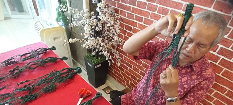 PANTANG MENGELUH : Made Kandra mahir membuat aneka kerajinan anyaman. (foto: adrian suwanto/radar bali )