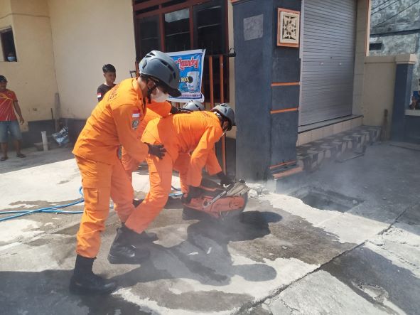 BIKIN KAGET: Proses pembongkaran gorong-gorong oleh petugas untuk evakuasi mayat dengan cara gergaji beton.