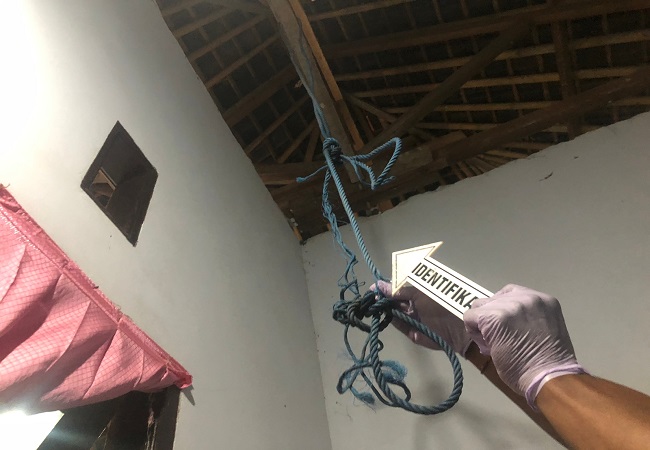 Aparat kepolisian saat melakukan olah TKP di lokasi kamar tempat I Made AD gantung diri. (ist)