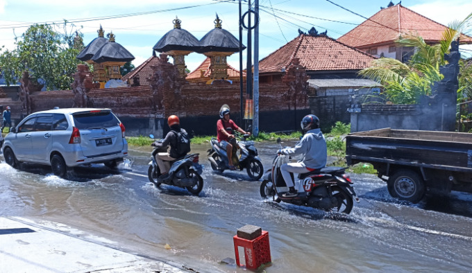 GARA-GARA SALURAN AIR TERSUMBAT : Genangan air di Jalan Gunung Salak Utara, Denpasar Barat. (adrian suwanto/radar bali)