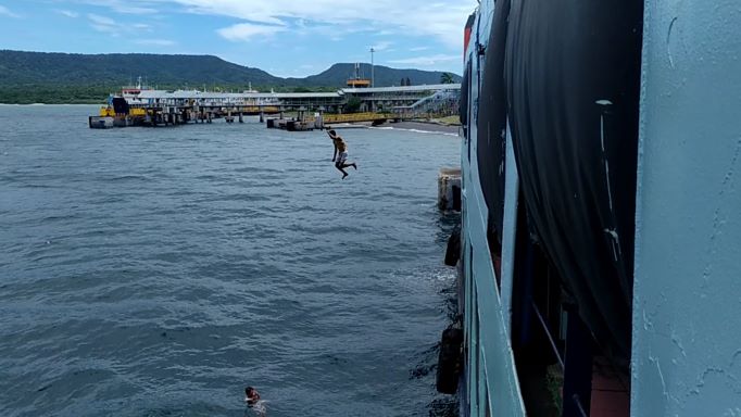 TUNGGU LEMPARAN UANG KOIN: Aksi anak logam merebut uang koin recehan di pelabuhan Gilimanuk dengan melompat dari dek kapal lalu berteriak lempar uang. Foto: M Basir/Radar Bali